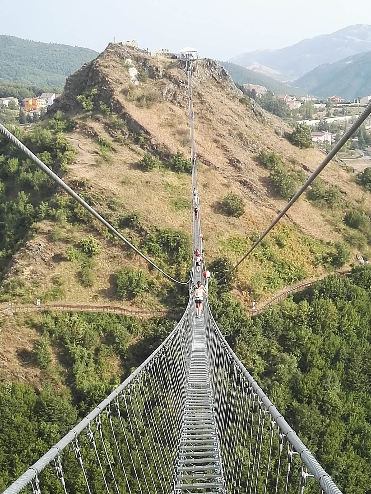 Attraversamento di un ponte tibetano sospeso, un'attività immersiva ideale per percorsi di team-building aziendale con impatto positivo sul territorio